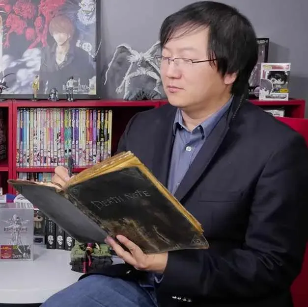 author-tsugumi-ohba-holding-a-death-note-32fcf6e1-d104-4aba-976c-98d6f61350ba.webp